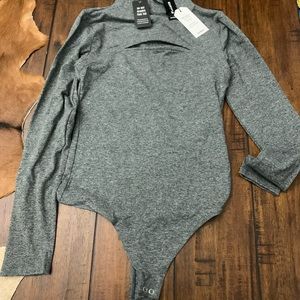 Body contour body suit, long sleeve, grey in color. Never worn, still has tags.